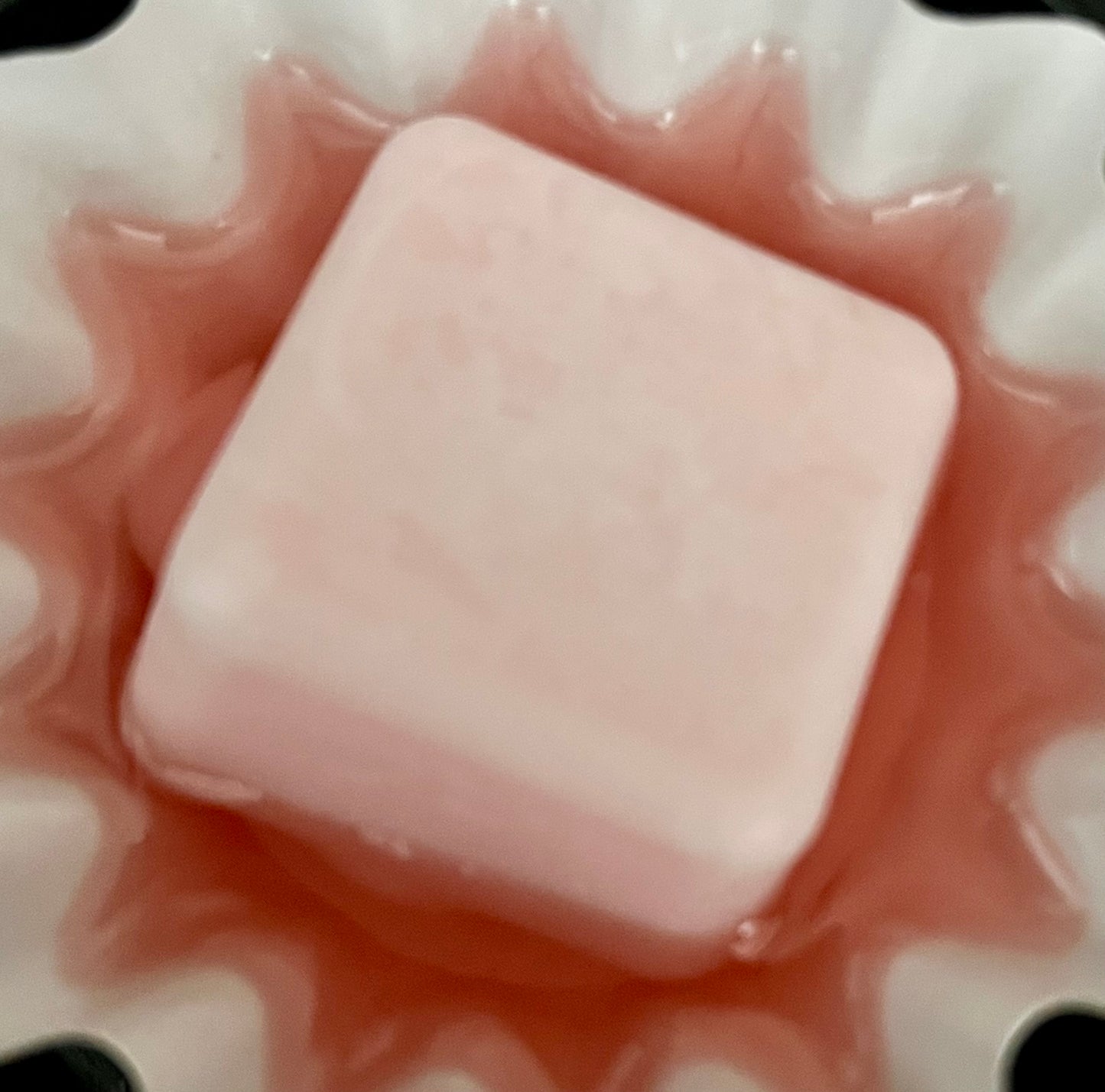 Close-up of a pink Lucasta Blossom & Dew wax melt showing texture and shape