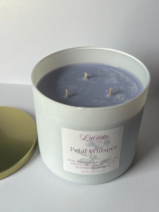 Lucasta Petal Whisper Candle in a white container with a label on a light gray background
