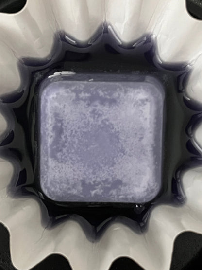 Close-up of a Lucasta Petal Whisper lavender wax melt melting in a warmer dish