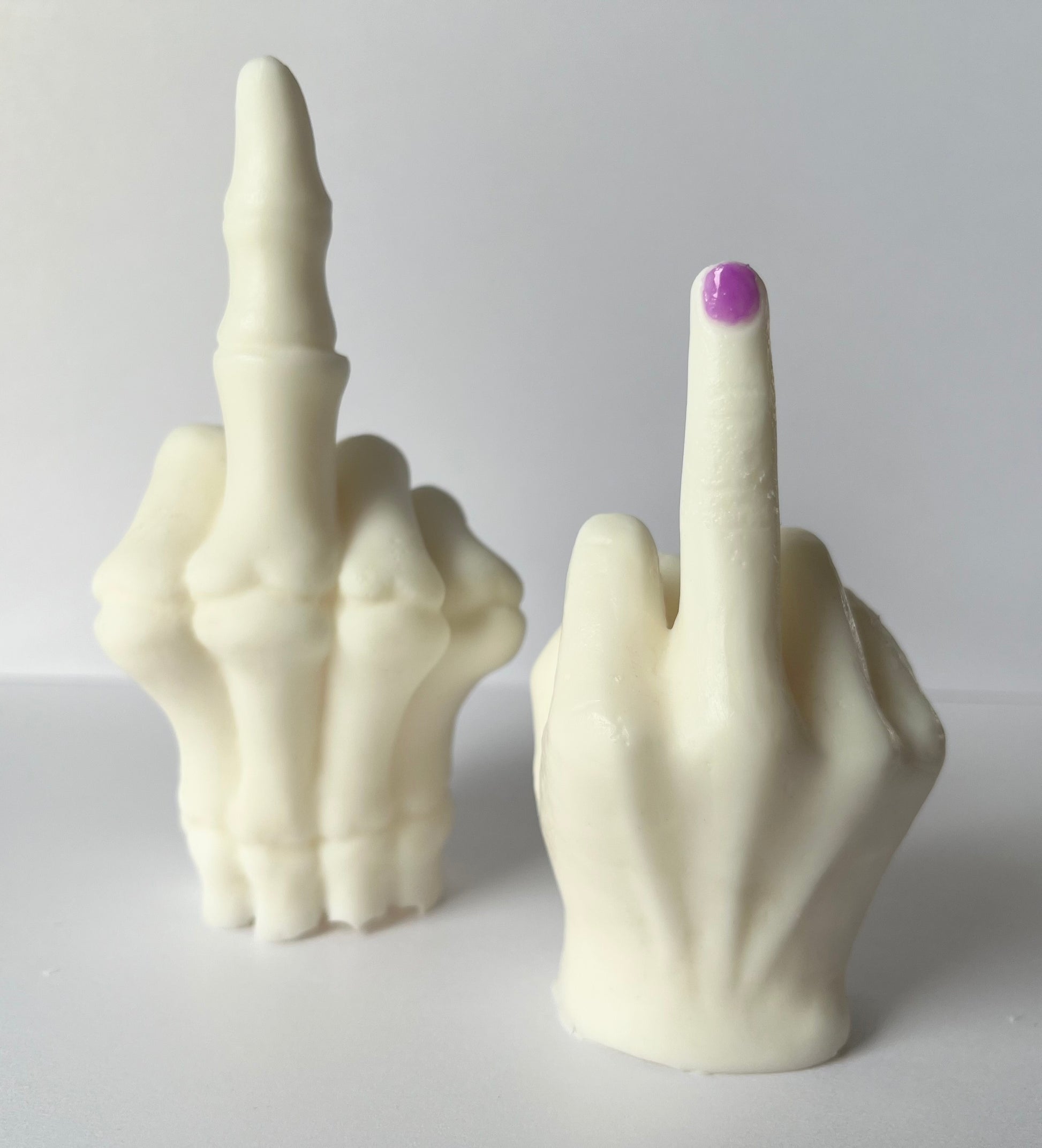 Lucasta Middle Finger wax melts showing skeletal and purple nail versions side by side, front view on white background