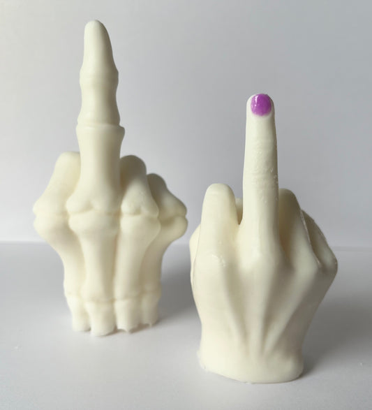 Two wax middle finger hand sculptures, one with a purple nail, one skeletal, on a white background