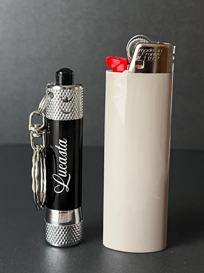 Lucasta Mini Flashlight Keychain shown next to a standard lighter for size comparison