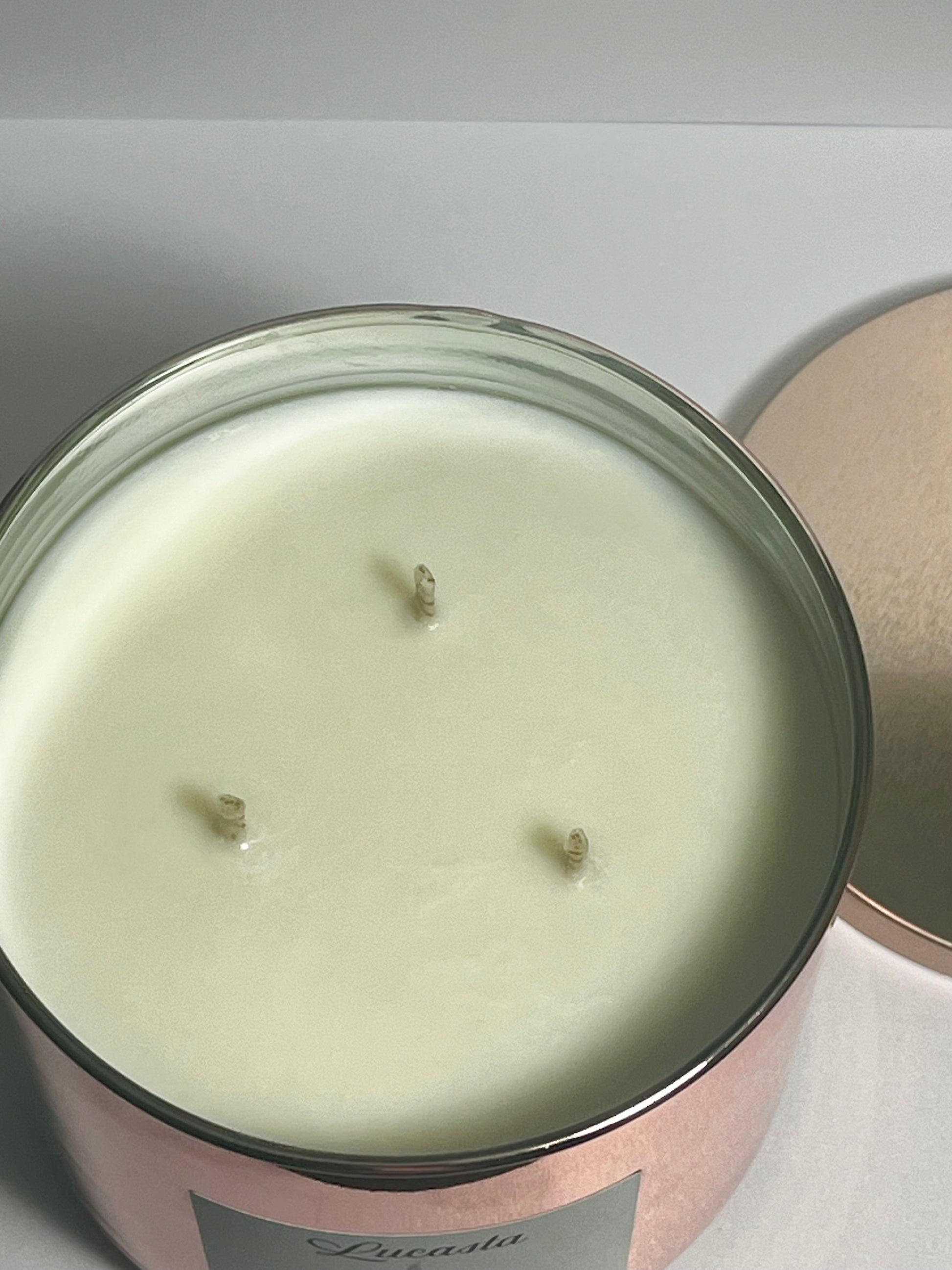 Lucasta Pure unscented 3-wick soy candle in rose gold jar showing wax surface, top-down view