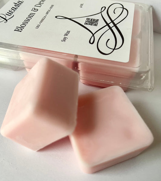 Pink wax melts with a clear container and 'Blossom & Dew' label on a light background