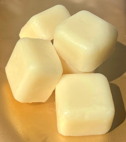 Five Lucasta Silk Melts white massage cubes arranged on a gold background