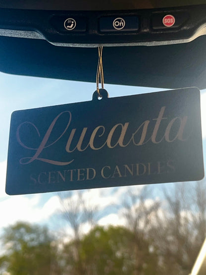 Lucasta Signature air freshener hanging from a car rearview mirror, lifestyle shot
