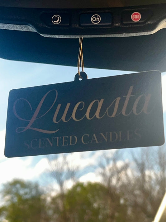 Lucasta Signature air freshener hanging from a car rearview mirror, lifestyle shot