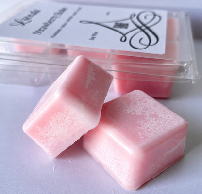Lucasta Candles Strawberry Shake soy wax melts in soft pink, shown as individual cubes in front of the labeled clamshell packaging