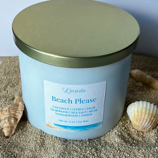 Lucasta Candles Beach Please soy candle in a white jar with gold lid, styled with seashells on sand