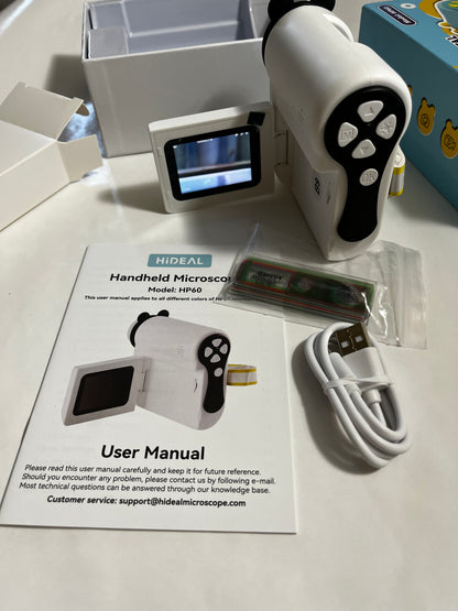 White and black handheld microscope kit with its accessories laid out on a white surface, including a user manual, USB cable, battery, storage card, and packaging box.