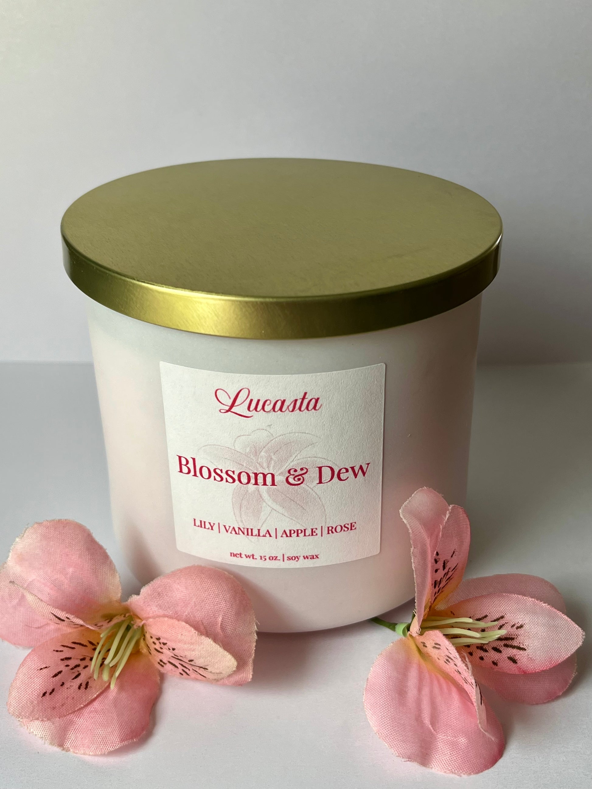 Lucasta Blossom & Dew candle with a gold lid on a white background
