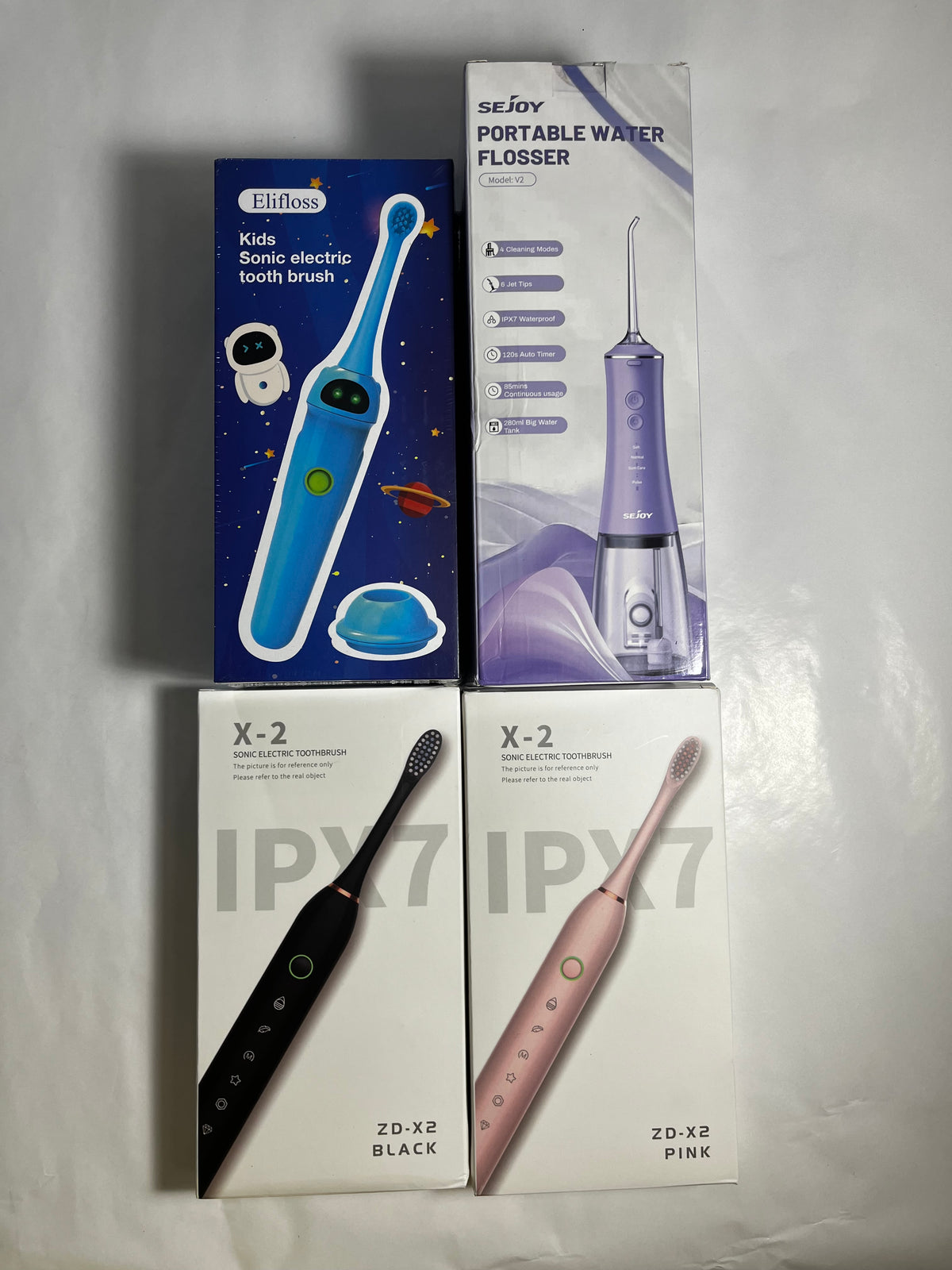 Front packaging of family oral care bundle with black and pink adult toothbrushes, kids' toothbrush and SEJOY water flosser
