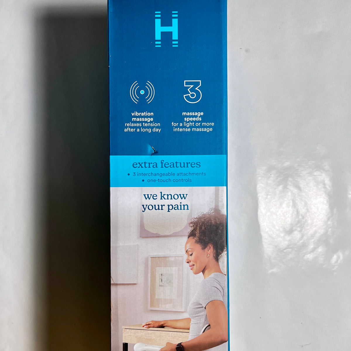 Side of HoMedics massager packaging showing three speeds and interchangeable attachments