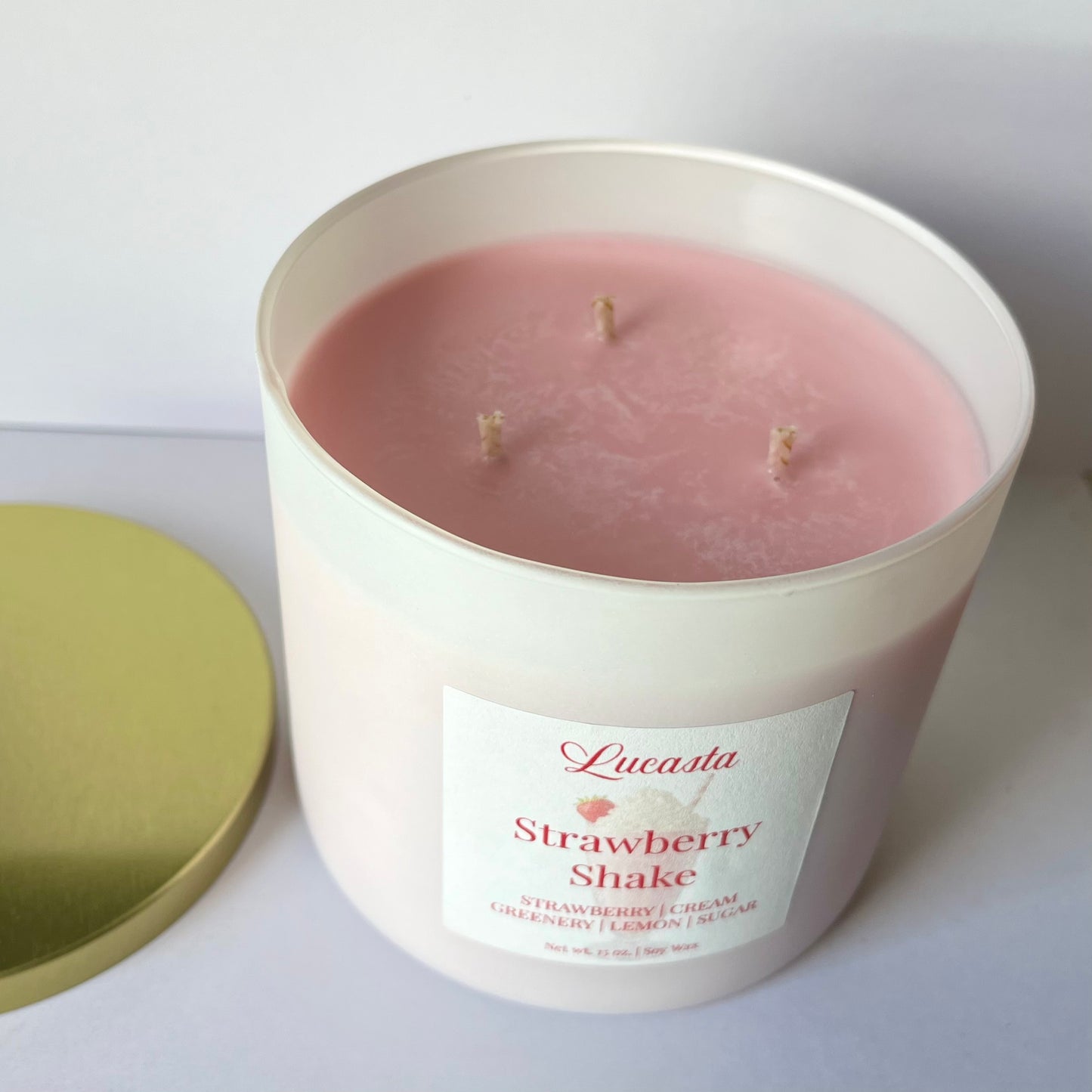 Lucasta Candles Strawberry Shake soy candle with lid removed showing soft pink wax and three wicks