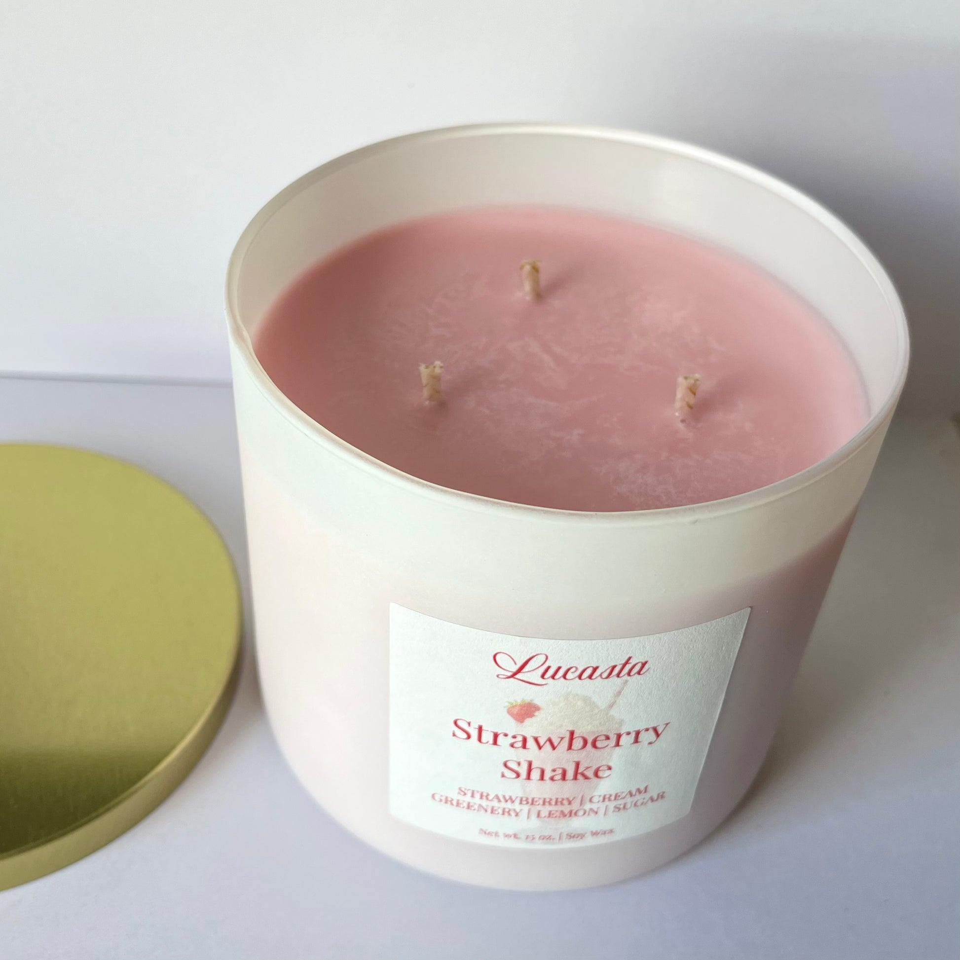 Lucasta Candles Strawberry Shake soy candle with lid removed showing soft pink wax and three wicks